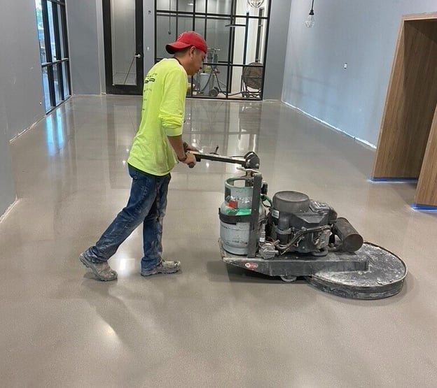 CustomCrete employee polishing the cement