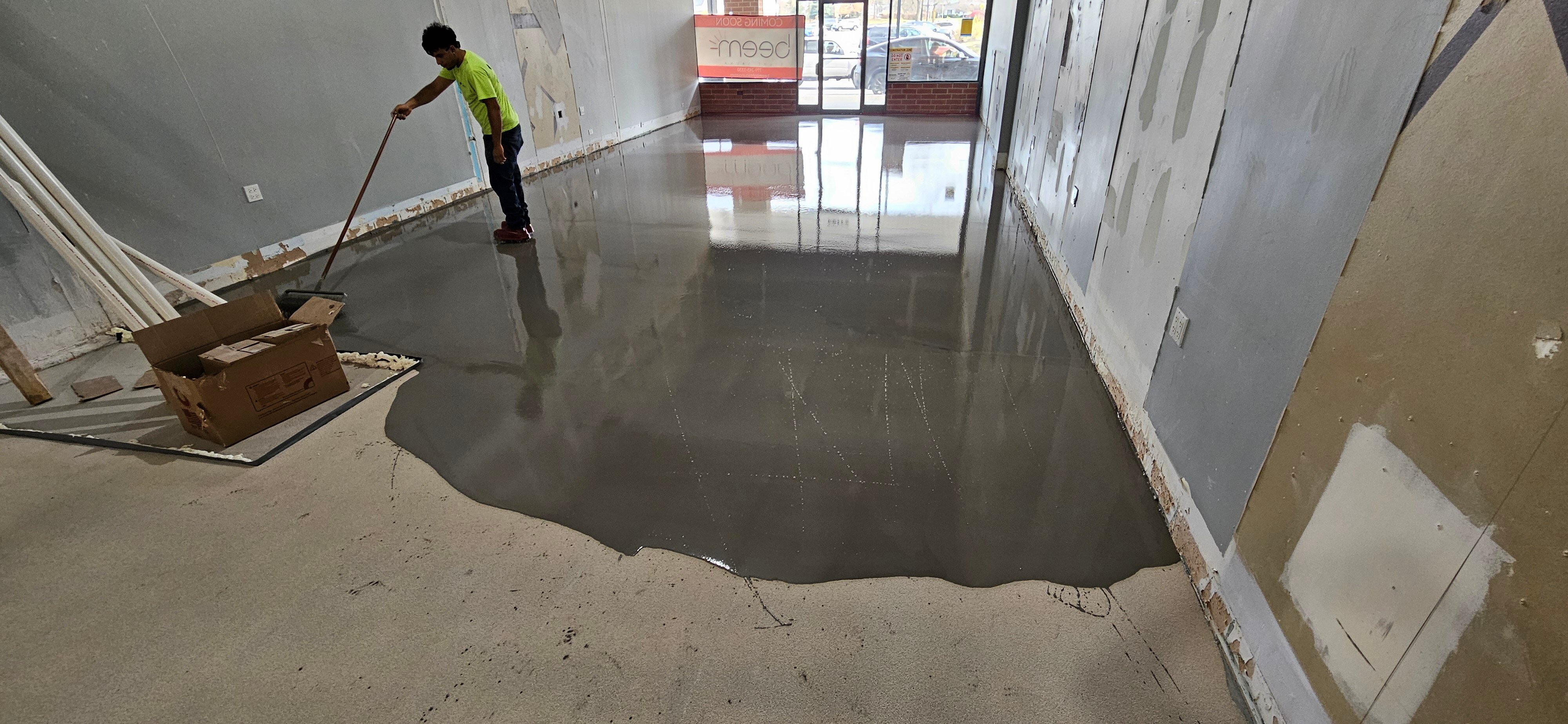  CustomCrete employee spreads Rapid Set Tru PC polished overlay over the concrete floor of a Chicago business 