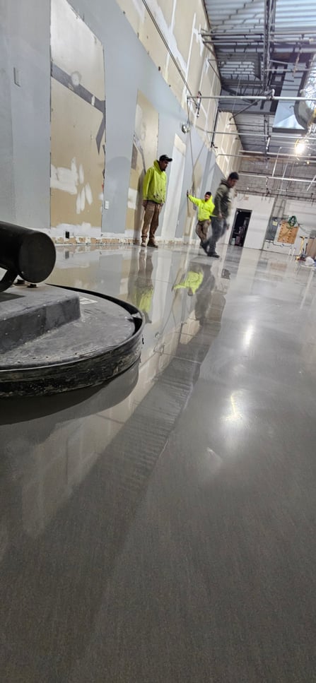 CustomCrete workers inspect their ARDEX K 521 sleek polished concrete floor for gloss and finish