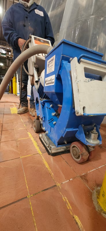 a CustomCrete worker does prep for a urethane cement floor in a factory